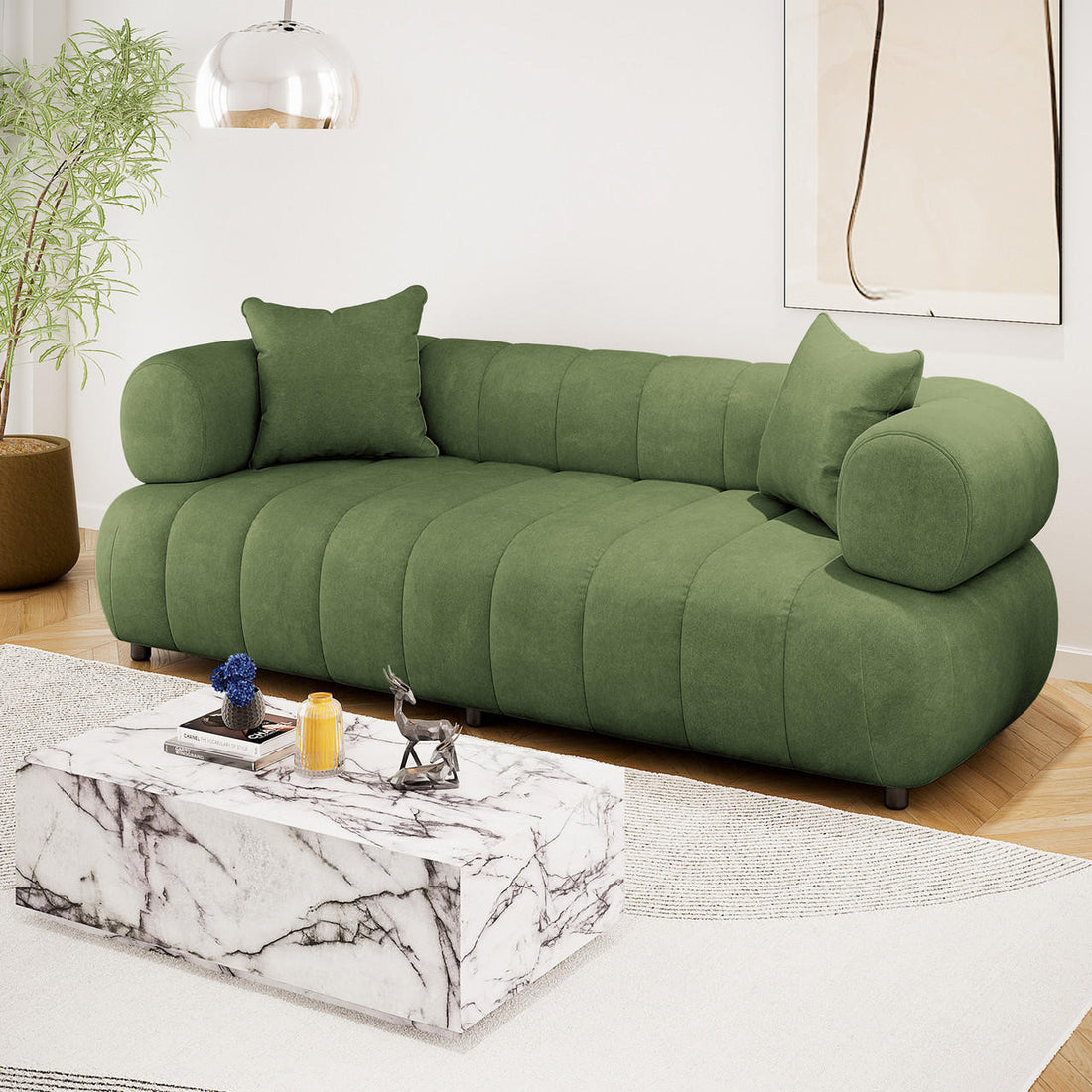 Samira 3 Seater Velvet Sofa in Prasinous Green, featuring plush, rounded cushioning with matching pillows, elegantly styled in a modern living room with a marble coffee table and abstract wall art.