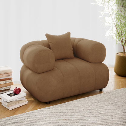 Samira Single Seater Velvet Sofa in Camel Brown, showcasing plush velvet upholstery and a single throw pillow, set in an elegant indoor space with a nearby potted plant enhancing its luxury appeal.