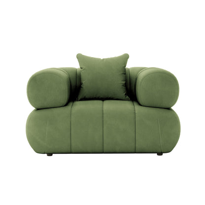 Samira Single Seater Velvet Sofa in Prasinous Green, featuring a plush, oversized design with rounded armrests and a loose back pillow. The sofa sits low on discreet feet, exuding modern elegance.