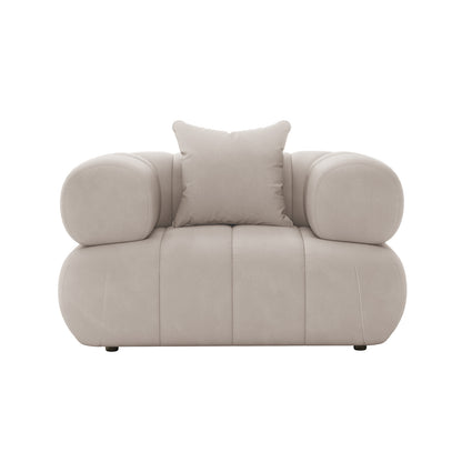 Samira Single Seater Velvet Sofa - Warm Beige, showcased on a white chair, highlighting the plush velvet texture, single pillow, and elegant design, emphasizing luxury and comfort.