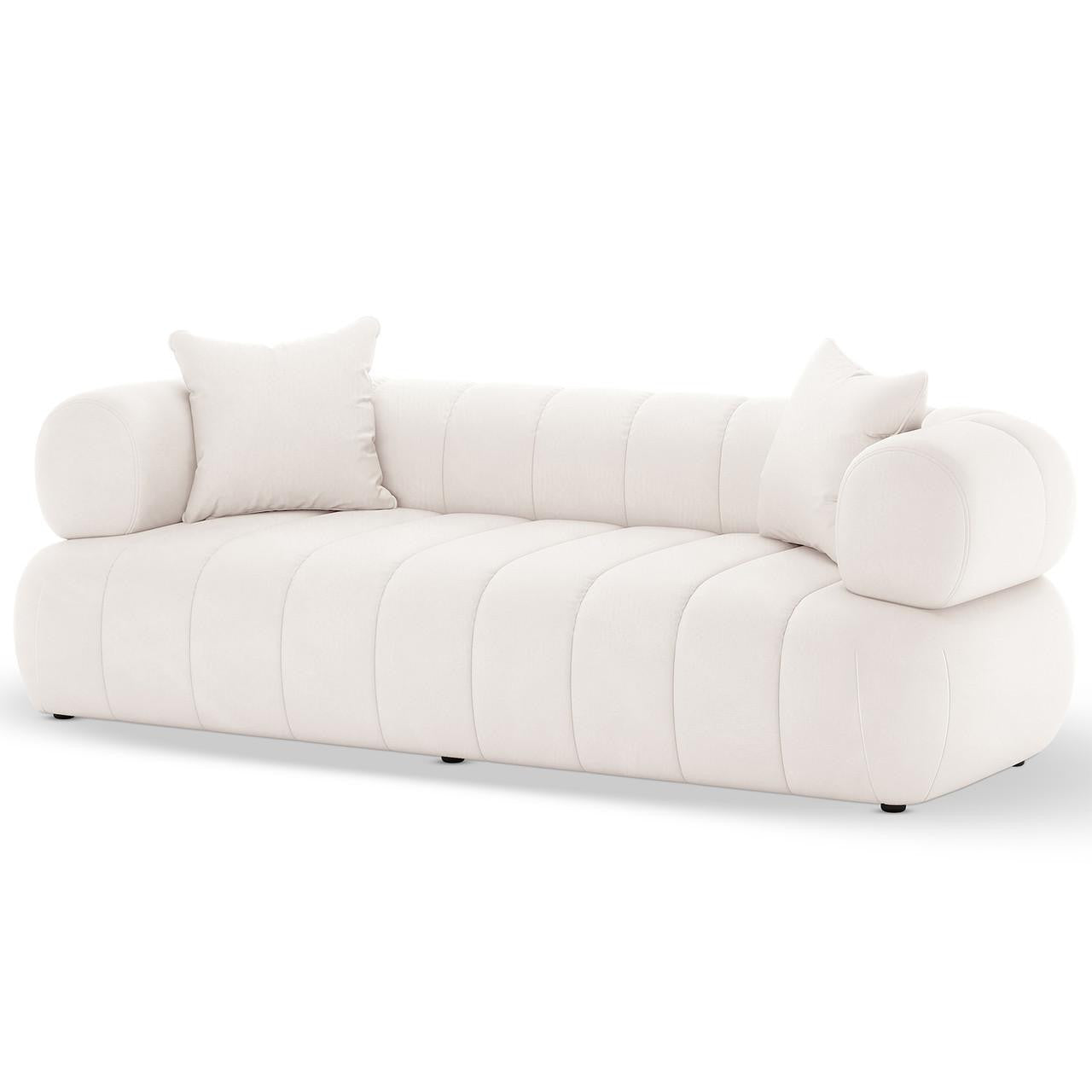Samira 6 Seater Velvet Sofa Set in Cream features a modern, low-profile design with channel-stitched upholstery, cylindrical bolster arms, and matching throw pillows, epitomizing elegance and plush comfort.
