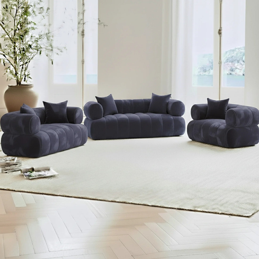 Samira 6 Seater Velvet Sofa Set in Navy Blue, a modular setup with two-seat loveseat, three-seat sofa, and armchair on a light rug, framed by French windows and a potted plant.