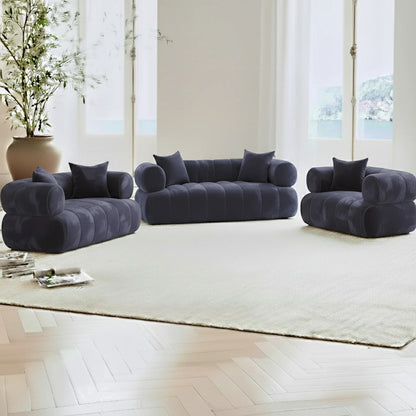 Samira 6 Seater Velvet Sofa Set in Navy Blue, a modular setup with two-seat loveseat, three-seat sofa, and armchair on a light rug, framed by French windows and a potted plant.
