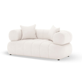 Samira 2 Seater Velvet Lounge in Cream, featuring a modern low-profile design with tufted seat, chunky cylindrical armrests, and two matching square pillows, set against a plain white background.