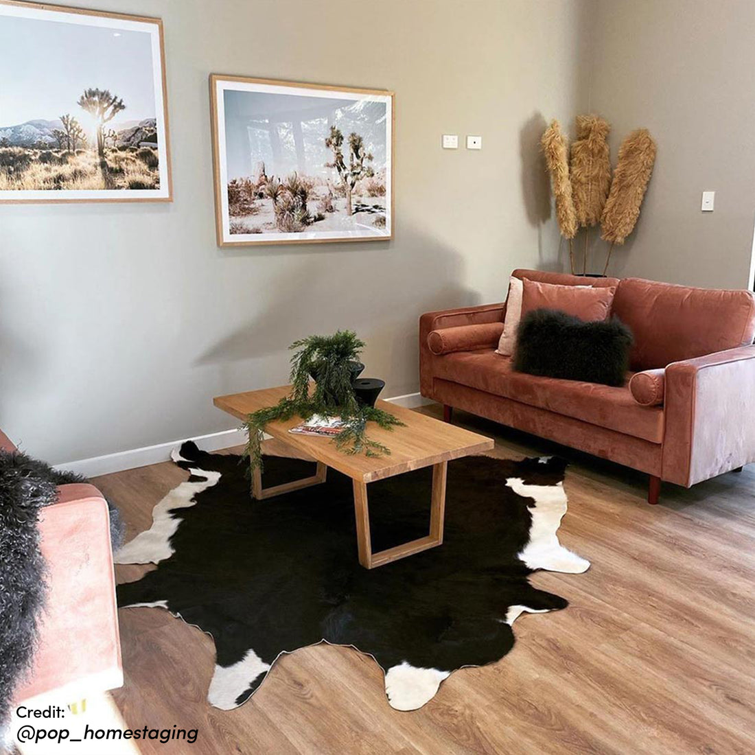 Sollia 3-Seater Velvet Sofa in Blush on a modern couch, set in a stylish living room with a coffee table, framed desert landscape, and contemporary decor elements.