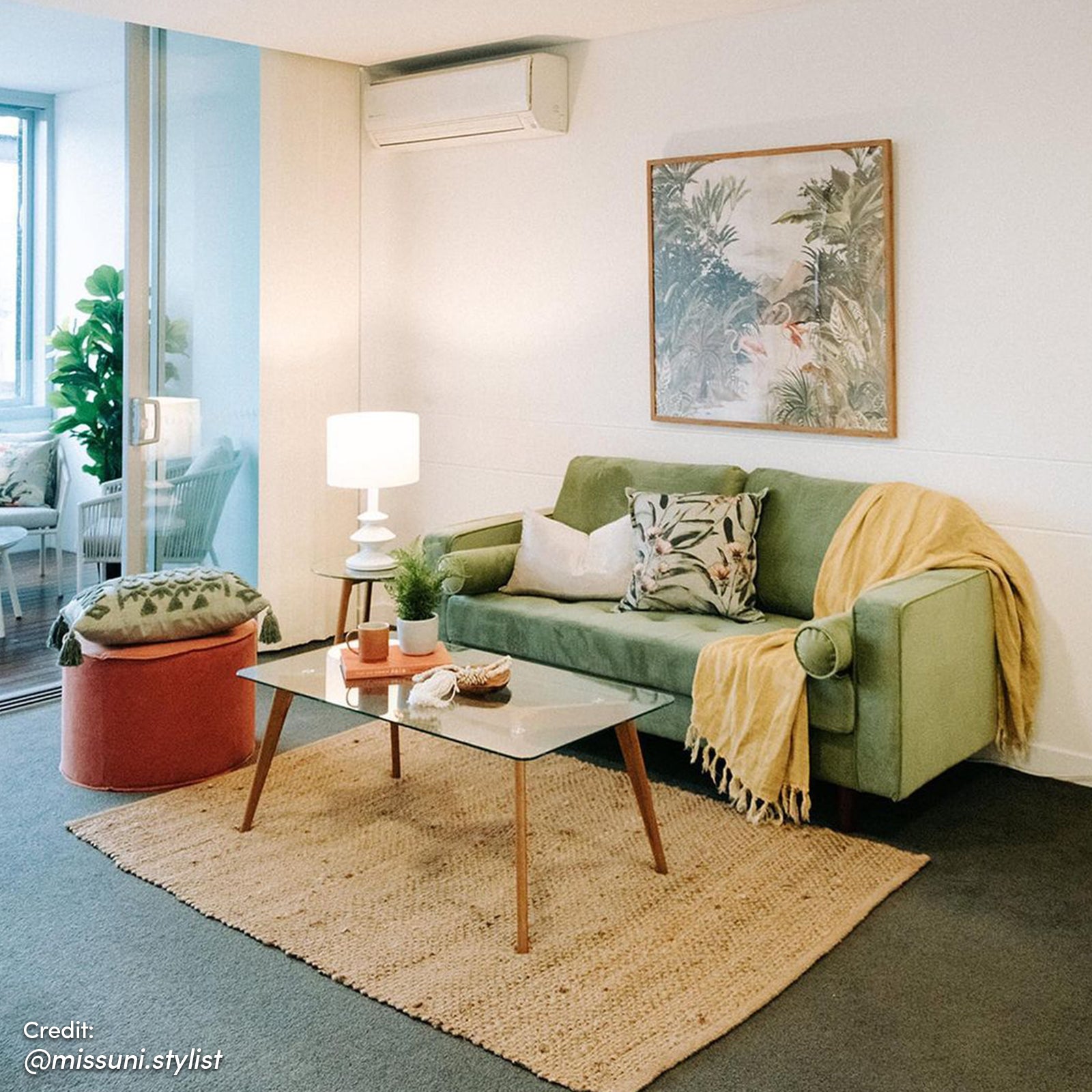 Sollia 3-Seater Velvet Sofa in jade green, featuring plush upholstery with two bolster pillows and a yellow blanket, is complemented by a coffee table, enhancing the elegant living room setting.