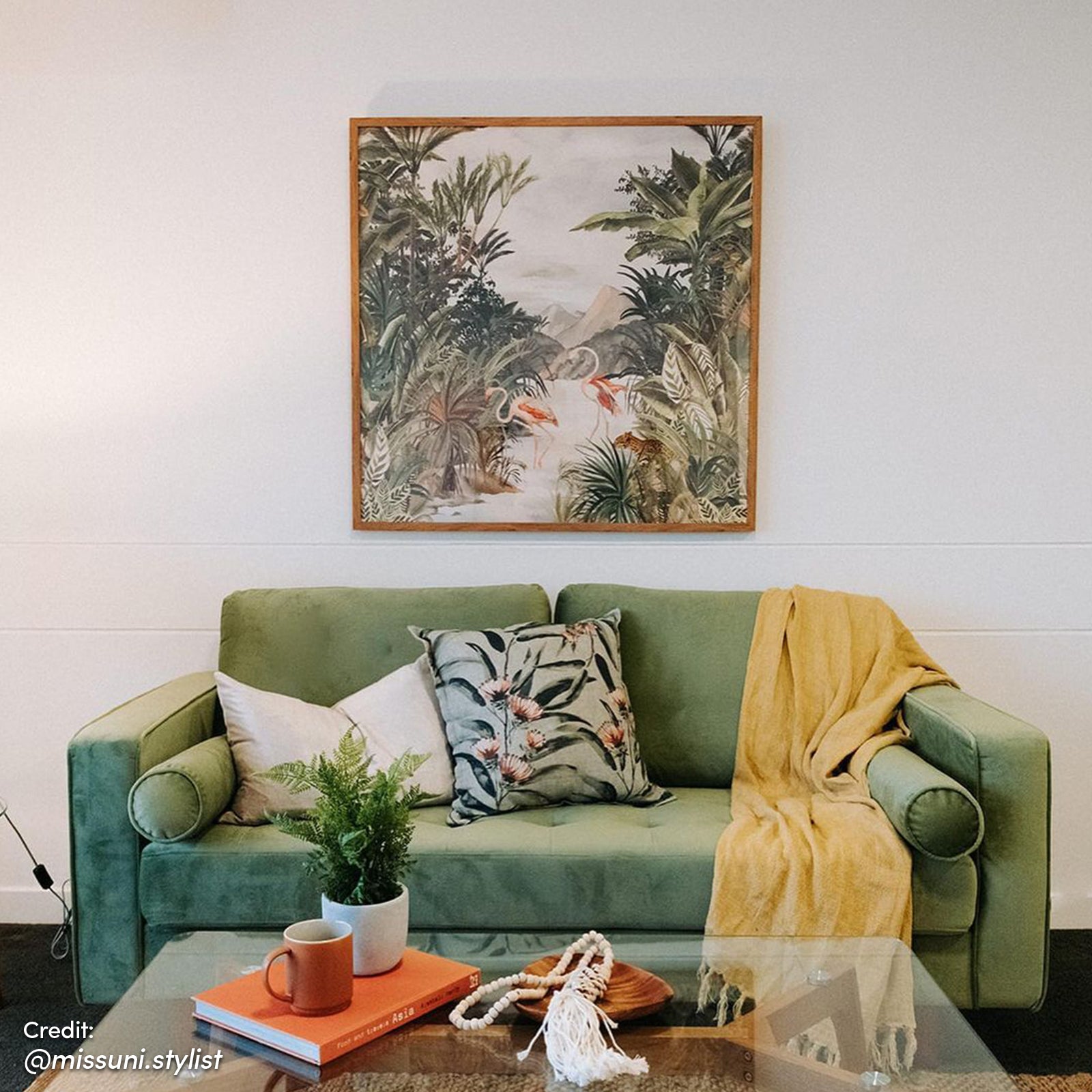 Sollia 3-Seater Velvet Sofa in Jade Green, elegantly styled with plush velvet upholstery, positioned beside a coffee mug, book, and decorative plant, enhancing a sophisticated living space.