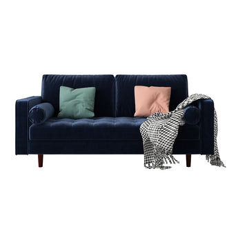 Sollia 3-Seater Velvet Sofa - Navy Blue, featuring sleek velvet upholstery with two matching bolster pillows, set on a blue couch with a black and white blanket, exuding modern elegance and comfort.