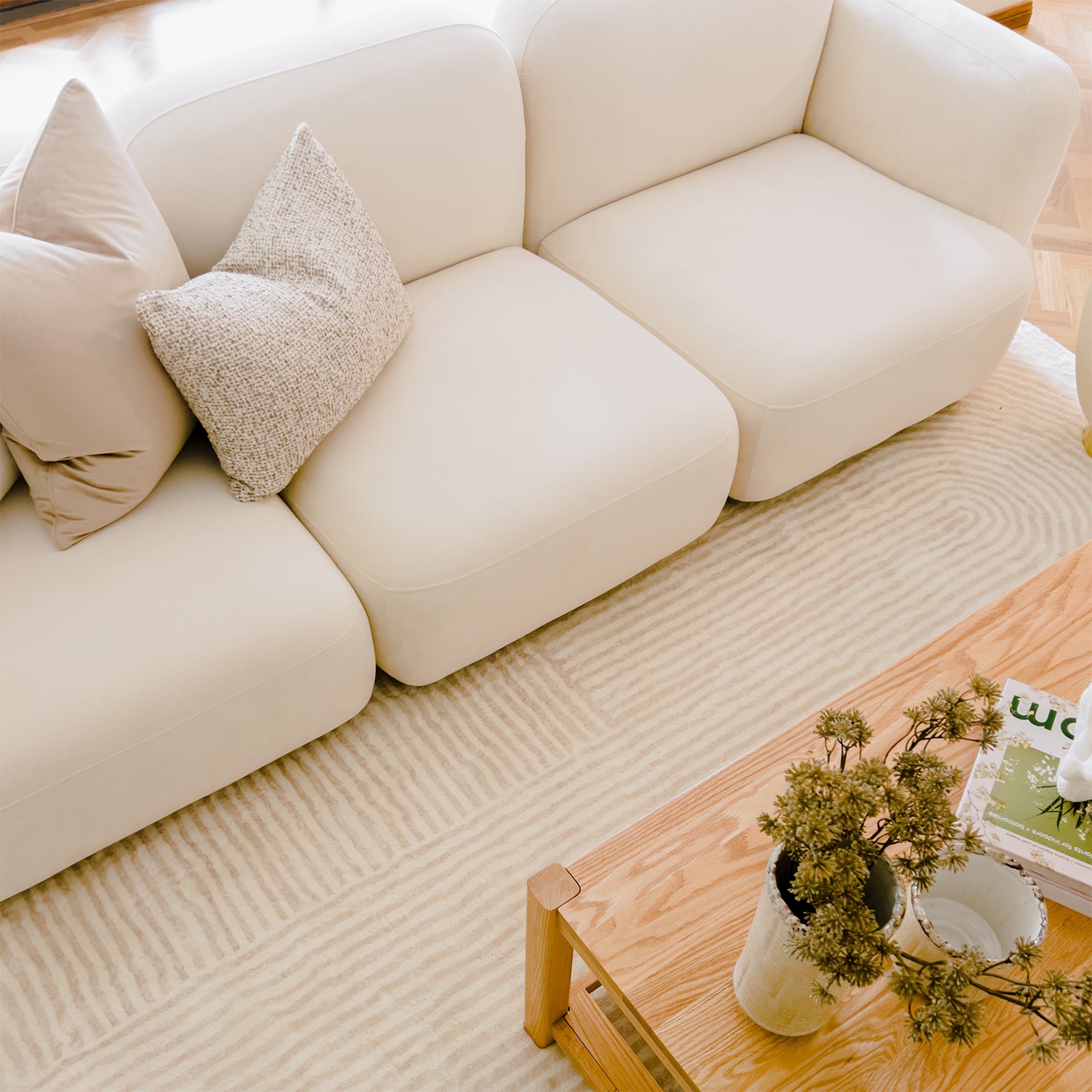 Close-up of the Soraya 3 Seater Modular Velvet Sofa Set showcasing its plush velvet upholstery and elegant design, highlighting the pillow detail on the cream white sofa's seating area.