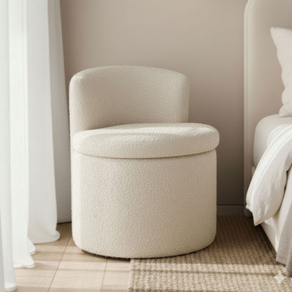 Sorra Bouclé Swivel Storage Accent Chair in Cream White beside a bed, featuring a short backrest and woven rug beneath, set in a neutral-toned bedroom with sheer curtains.