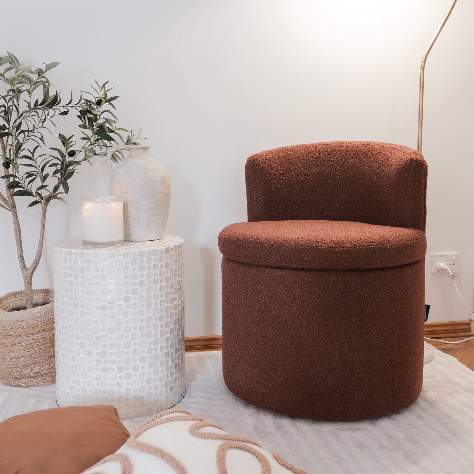 Sorra Boucle Swivel Storage Accent Chair in Rust Brown, featuring soft bouclé fabric, a low curved back, and hidden storage beneath the removable seat. Set in a cozy reading nook with a mosaic table.