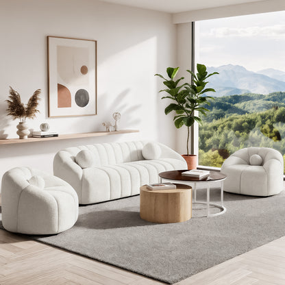 Trina 5 Seater Boucle Sofa Set with Pillows in Cream White, featuring channel-tufted design and curved lounge chairs, set in a bright minimalist living room with a large area rug and nested coffee tables.