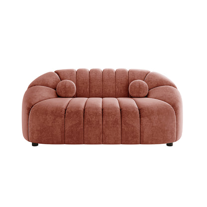 Trina 6 Seater Tufted Velvet Lounge Set in Blush features deep channel-stitched cushions, rounded armrests, and two cylindrical bolster pillows, showcasing a modern, curved silhouette on short feet.
