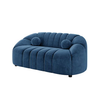 Trina 2 Seater Tufted Curved Velvet Sofa in Blue, featuring vertical channel tufting, round bolster pillows, and low-profile design on short legs, set against a plain white background.