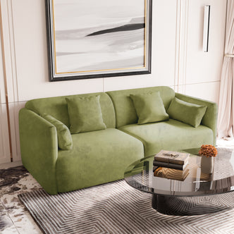 Vestalia 3 Seater Velvet Sofa in Olive Green, featuring a sleek, curved design with plush velvet upholstery. Positioned in a modern living room with a smoked-glass coffee table and geometric rug.