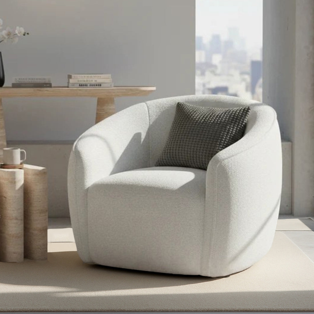 Yara Bouclé Accent Chair in Cream White, featuring softly rounded design, light-neutral upholstery, and a textured throw pillow, set on a matching rug beside a sculptural side table with a mug.
