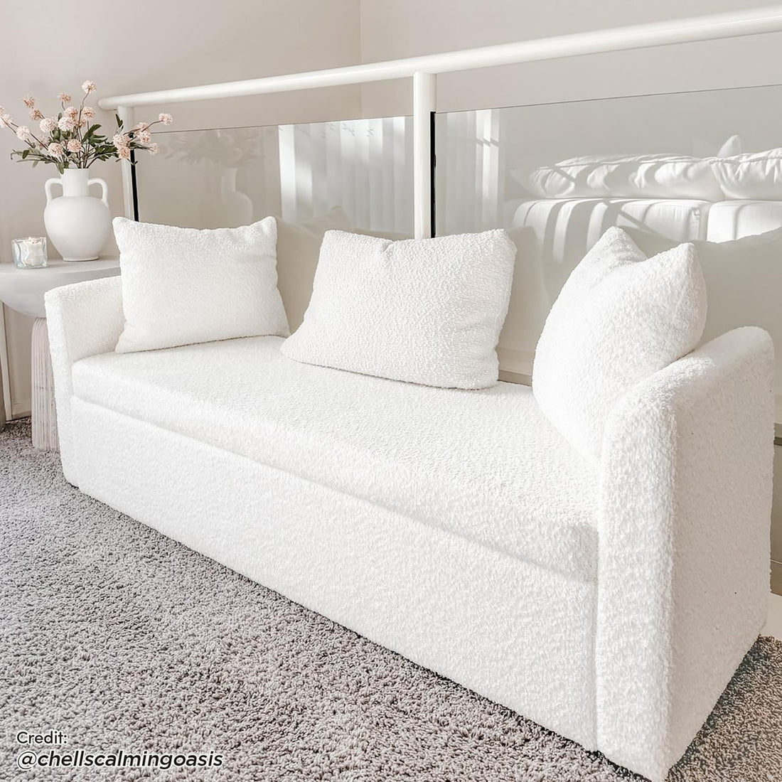Zamira Large Boucle Storage Ottoman Bench in Cream White, featuring textured bouclé upholstery, three square back cushions, and hidden storage, placed on a light gray carpet in a softly lit room.