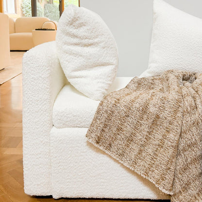 Zamira Large Boucle Storage Ottoman Bench in Cream White, featuring soft bouclé upholstery, set on herringbone flooring with a knitted throw, showcasing its elegant, modern design and functionality.