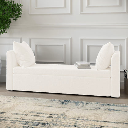 Zamira Large Boucle Storage Ottoman Bench in Cream White with bolstered arms, loose back cushions, and a book stack, set against a paneled wall, on a light rug with blue-gray accents.