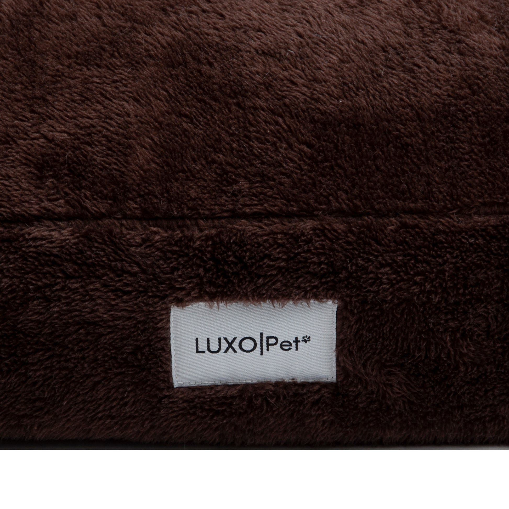 Close-up of brown plush fabric with LuxoPet label on white background