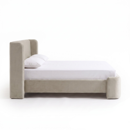 Side view of a fully upholstered bed on a white background