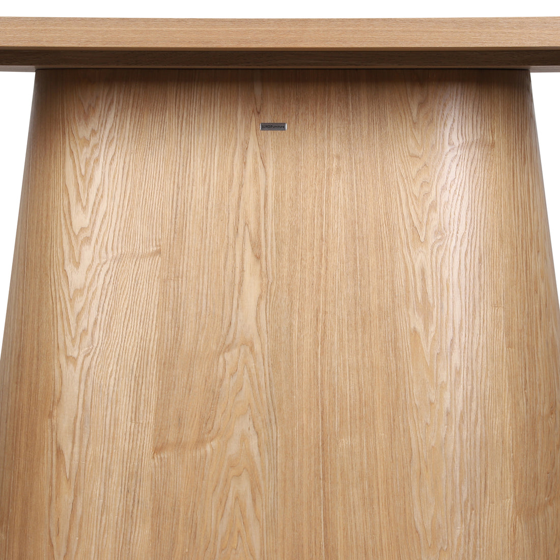 Close-up of the Gigi 180cm Oval Wooden Dining Table in Oak, showcasing its light-oak pedestal base with visible wood grain and a LUXO Furniture nameplate beneath the tabletop.