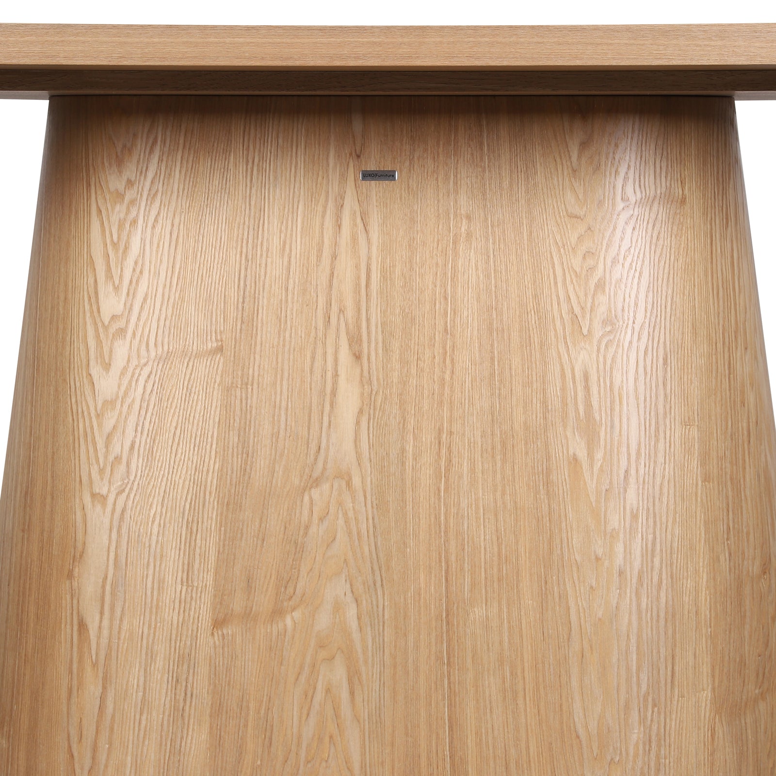 Close-up of the Gigi 180cm Oval Wooden Dining Table in Oak, showcasing its light-oak pedestal base with visible wood grain and a LUXO Furniture nameplate beneath the tabletop.