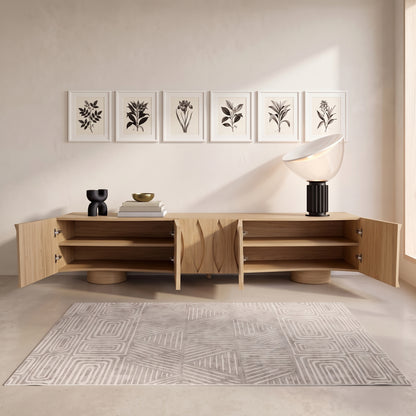 Wooden media console styled in a minimalist room with artwork and decor