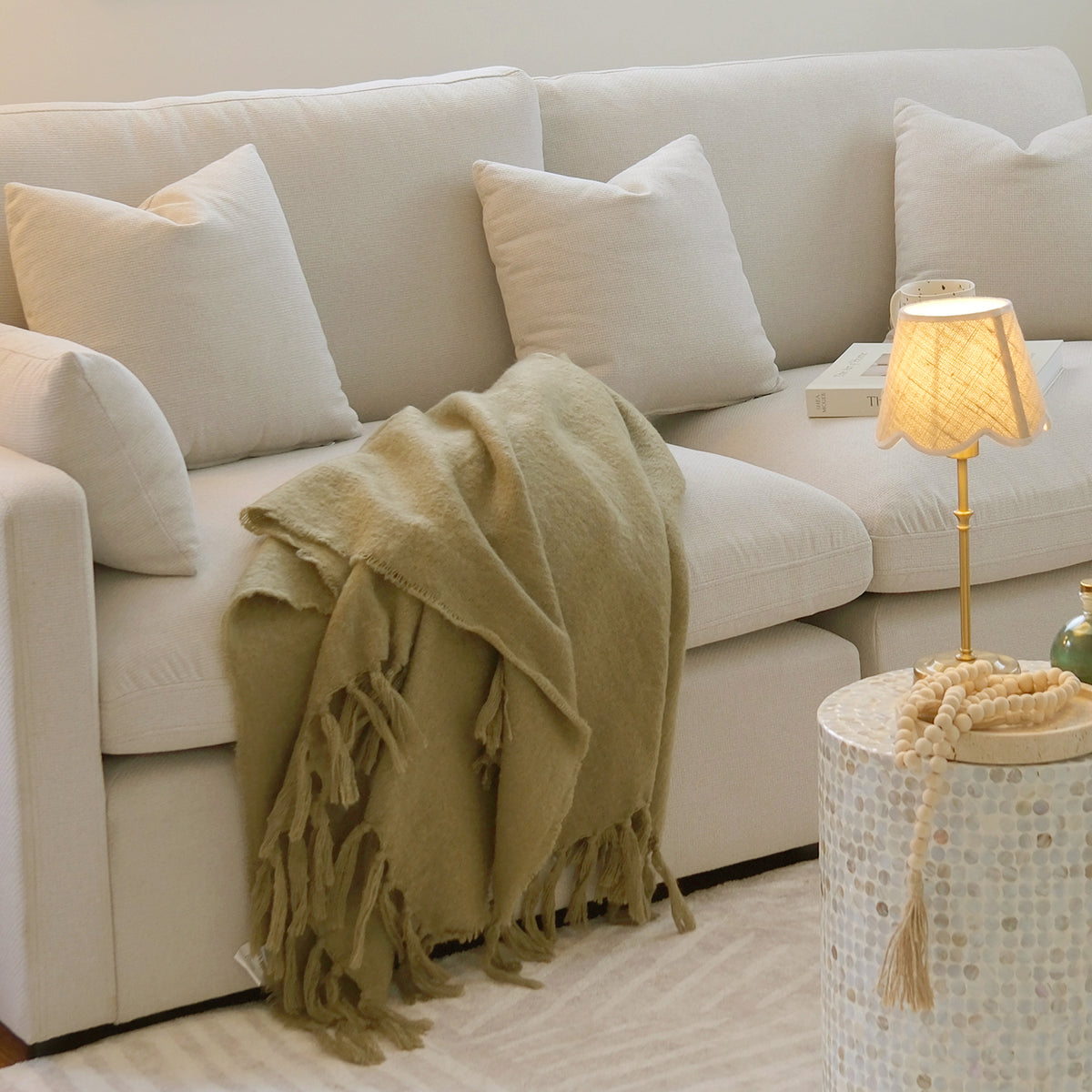 Light-colored sectional sofa in a softly lit living room with decor