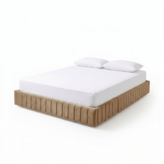 Three-quarter front view of beige upholstered bed frame with white mattress and pillows on white background