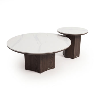 Two nesting round tables with white marble-look tops and dark wood pedestal bases on a white background
