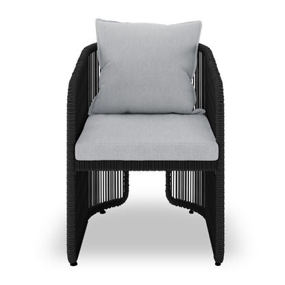 Vellora 4 Seater Wicker Outdoor Dining Set in Black features a modern lounge armchair with a black rope frame, light-gray cushions, and a sleek, contemporary design suitable for indoor or outdoor use.