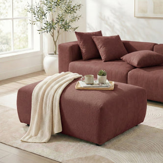 Sectional sofa with matching rust ottoman in a styled living room