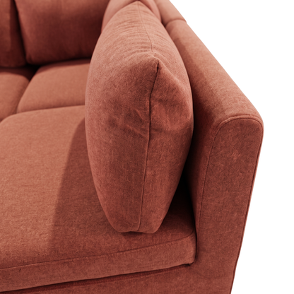 Close-up of rust terracotta sofa armrest and cushions