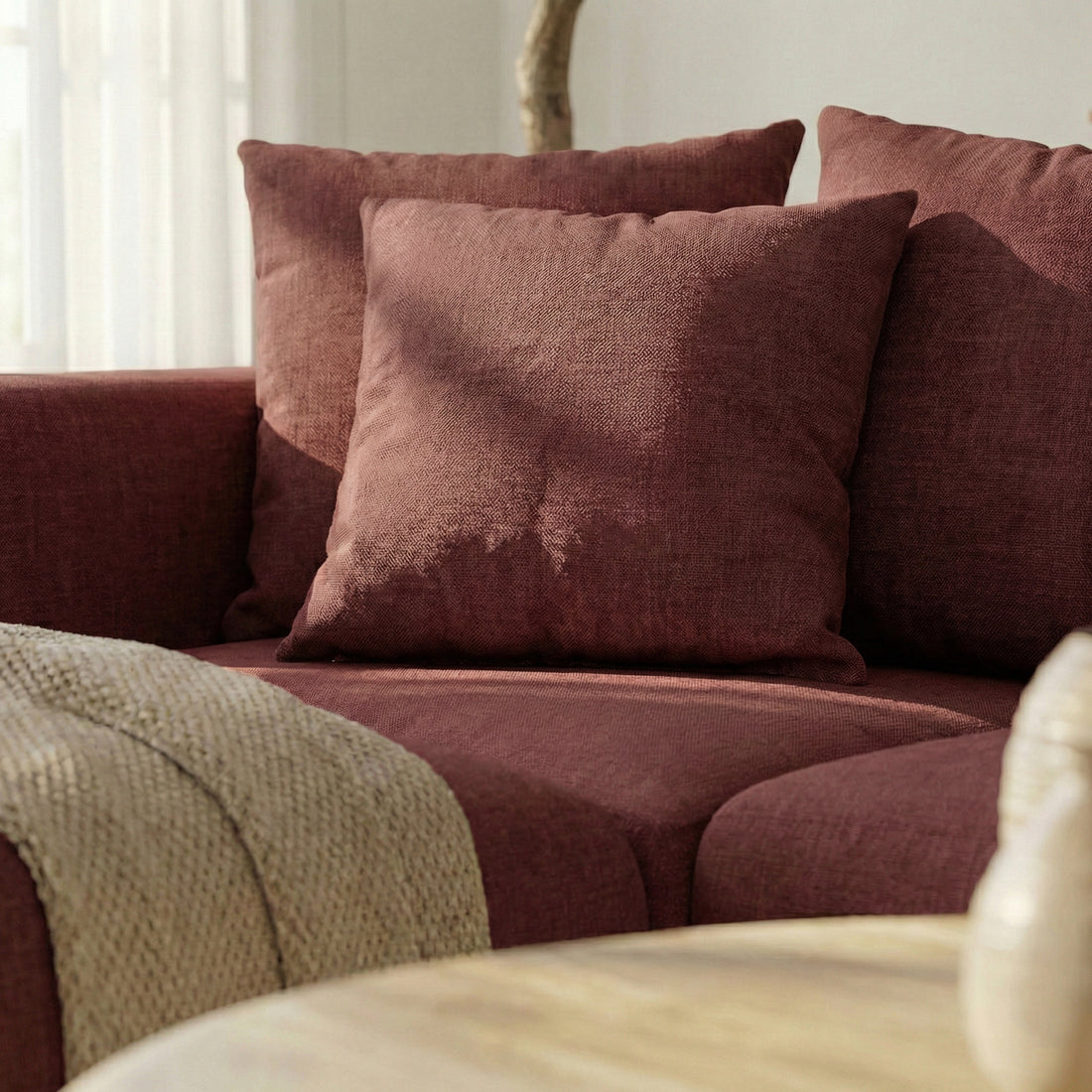 Close-up of sectional sofa corner with cushions and throw in a living room setting