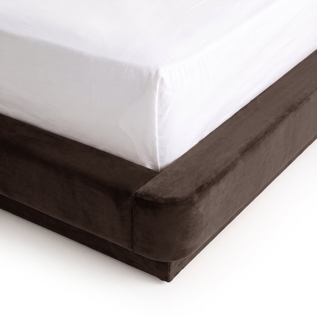 Close-up corner view of a bed with mattress and dark upholstered base