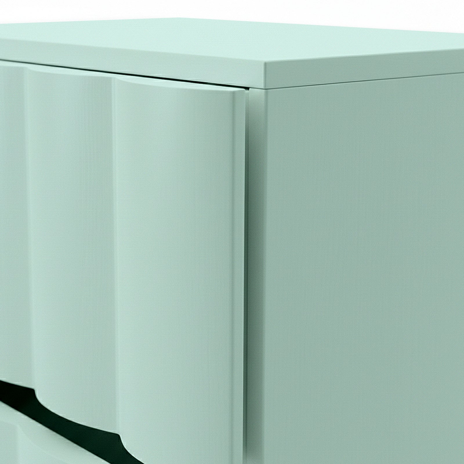Close-up of top corner and curved drawer fronts of pale cabinet on white background