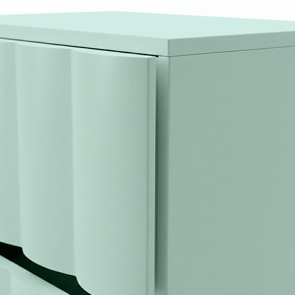 Close-up of top corner and curved drawer fronts of pale cabinet on white background