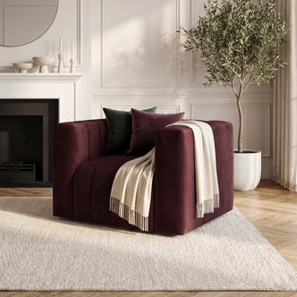 Dark Merlot armchair styled in a living room with pillows and throw blanket