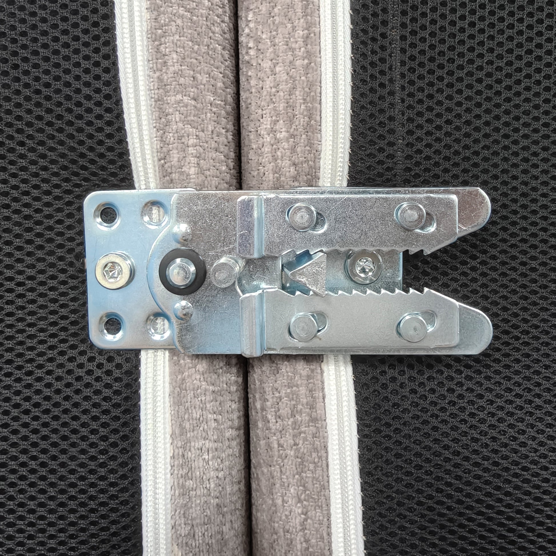 Close-up of a metal latch attached to fabric panels.