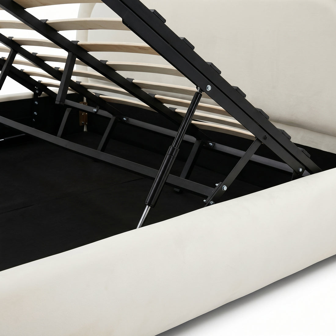 Close view of raised storage bed platform, wooden slats, gas lift, and under-bed compartment