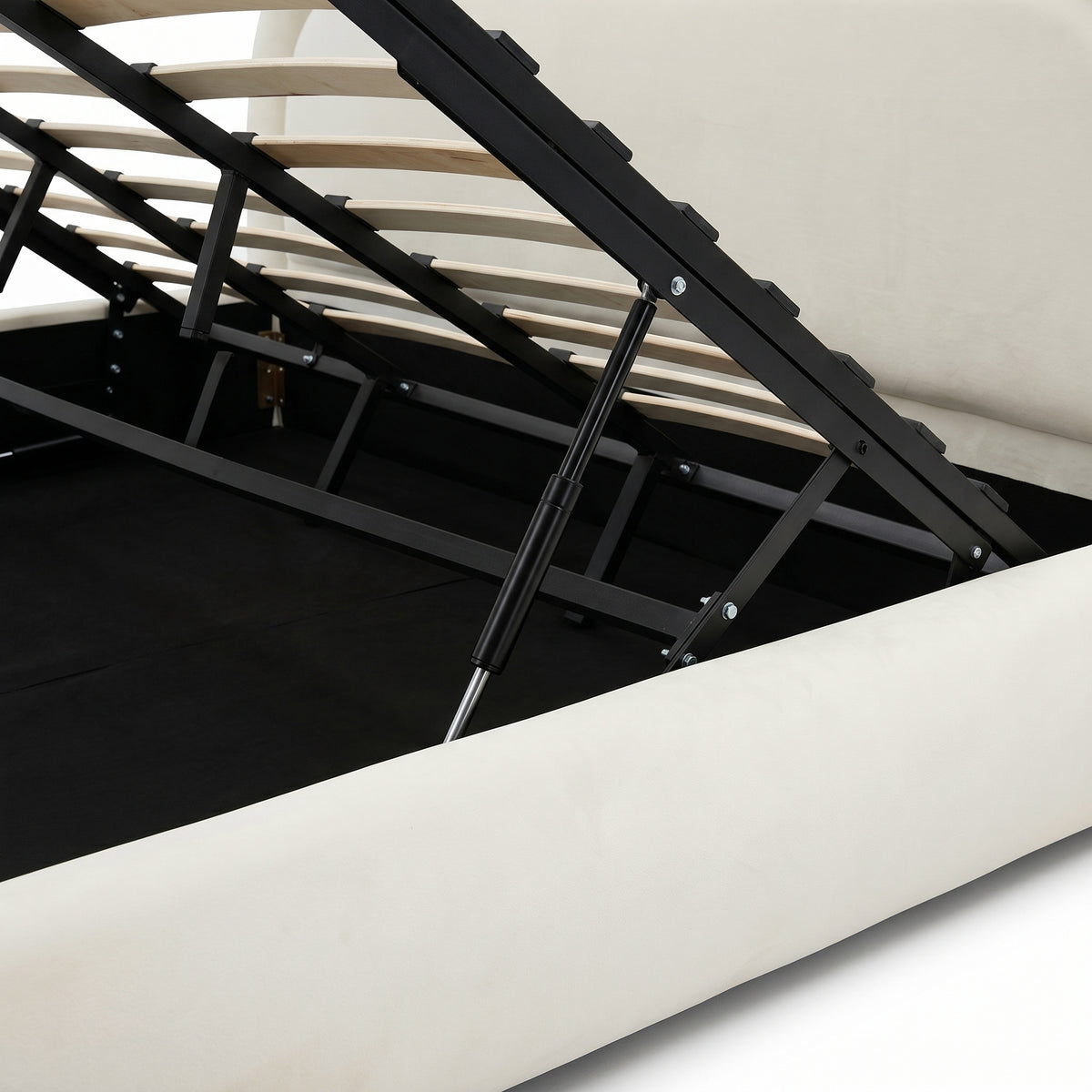 Close view of raised storage bed platform, wooden slats, gas lift, and under-bed compartment