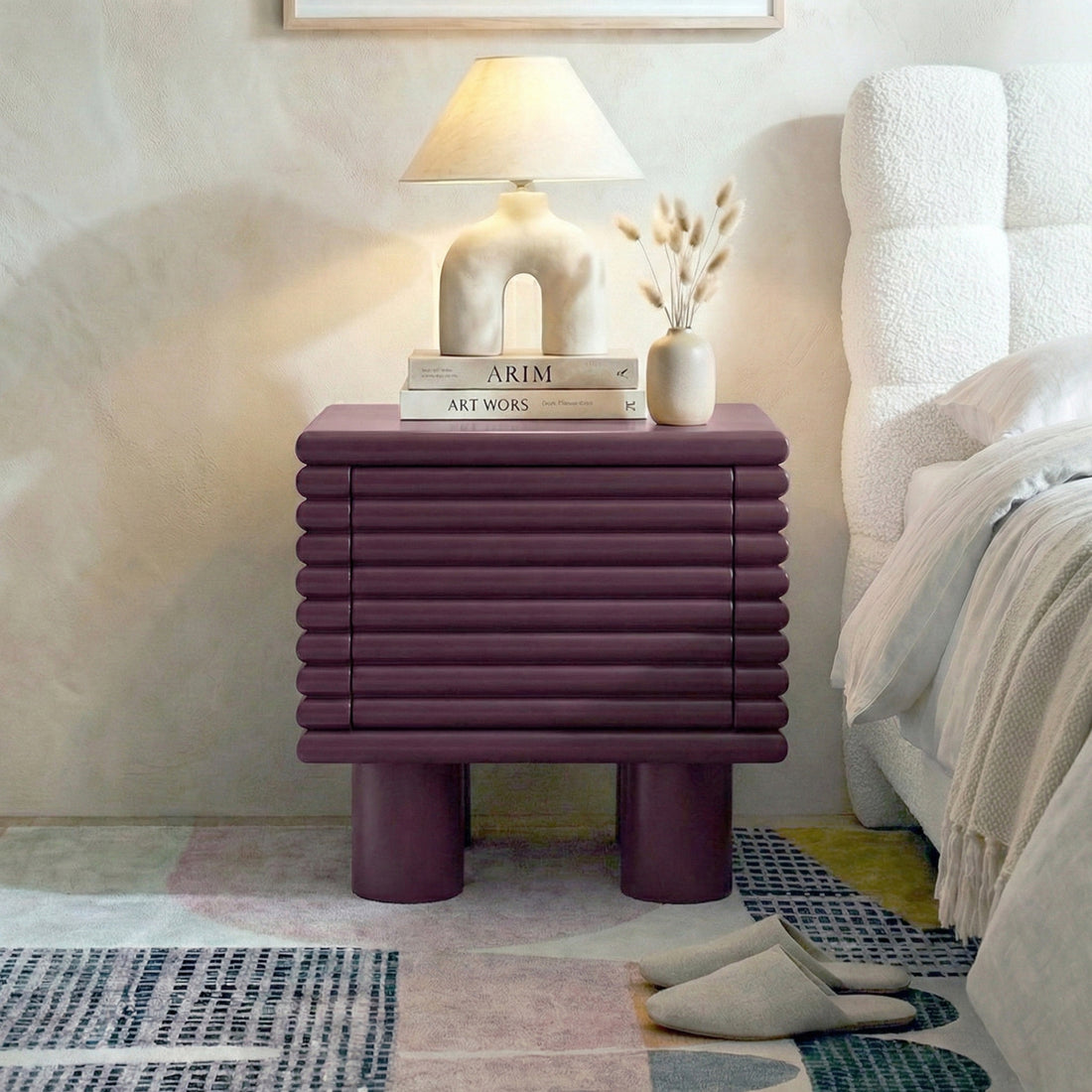 Plum ribbed nightstand styled in a cozy bedroom next to bed