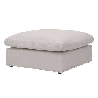 Light beige square ottoman with plush top and black feet on a white background