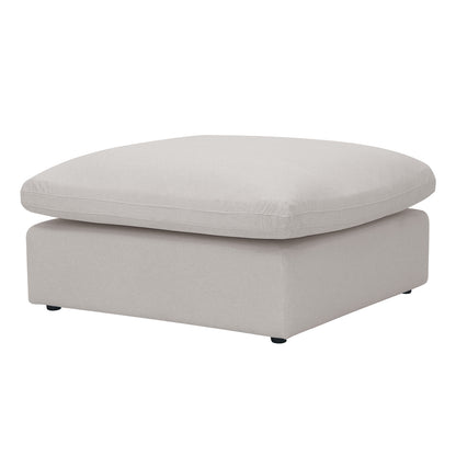 Light beige square ottoman with plush top and black feet on a white background