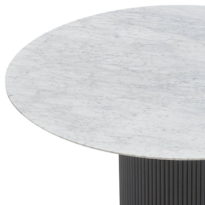 Gracie 120cm Round Marble Dining Table in Black showcases a white Carrara-style marble top with gray veining, supported by a dark, fluted pedestal base.