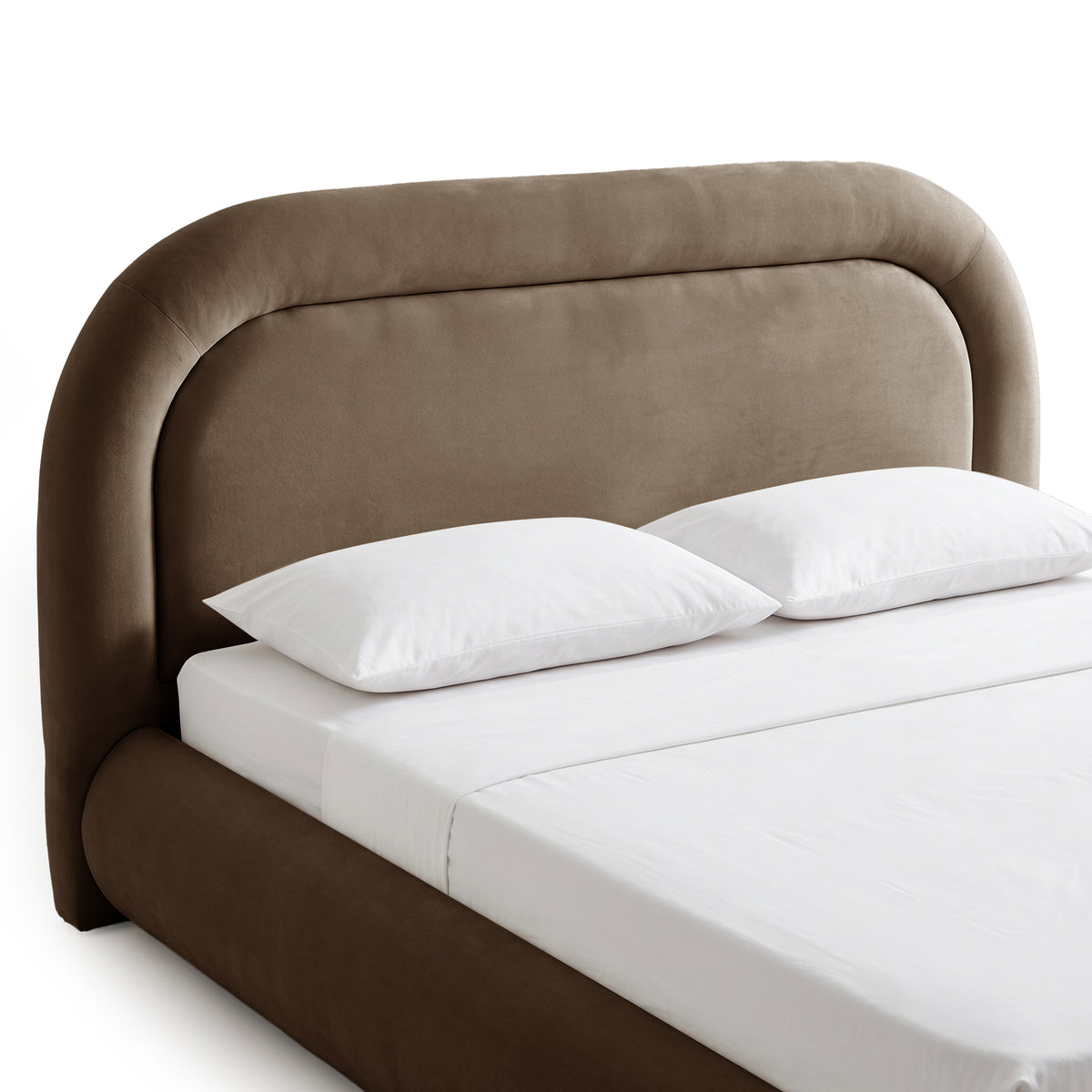 Close three-quarter view of a taupe upholstered bed with white bedding