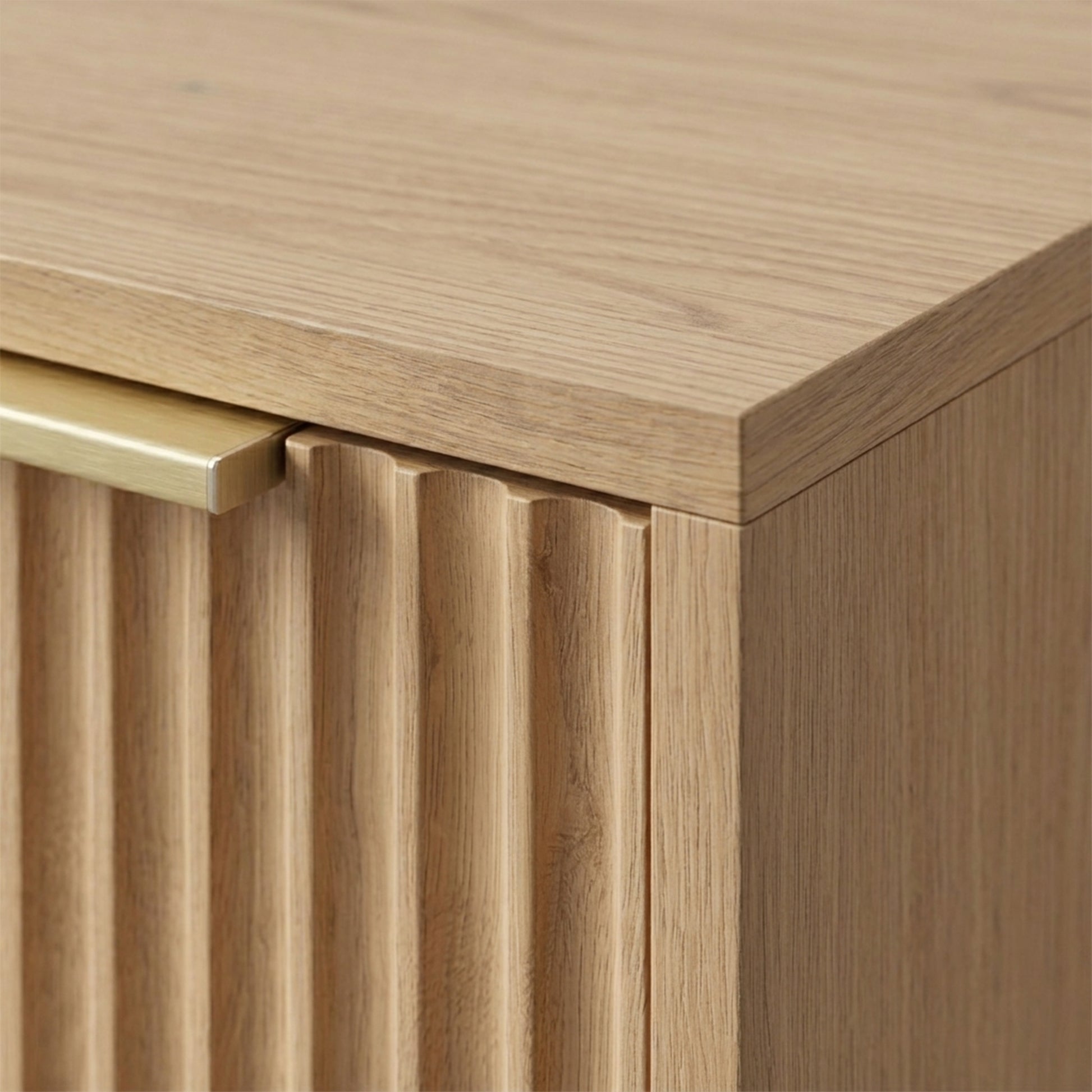Close-up of the top corner and front panel detail of a wooden cabinet on a neutral background