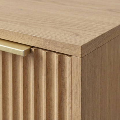Close-up of the top corner and front panel detail of a wooden cabinet on a neutral background