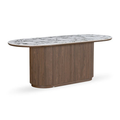 Oval dining table with fluted wooden base and stone-look top on white background